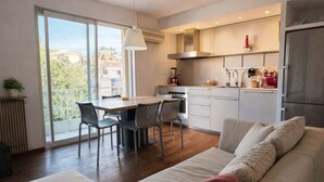 Een moderne woonkamer met een bank, een eethoek en een keuken.