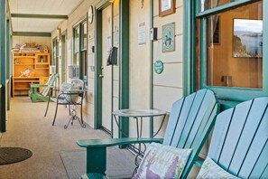 Une piĂšce confortable avec vue sur un plan dâeau, une petite table et une chaise avec un coussin.