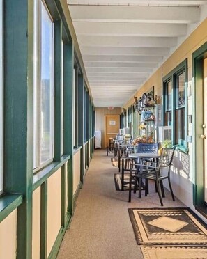 A corridor with a long table and chairs, large windows, and a door at the end. - Rm. 10, Queen, pet-friendly (Tahoe City)