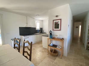 Eine kleine Küche mit Essbereich, einer Kaffeemaschine und einem gerahmten Bild an der Wand.