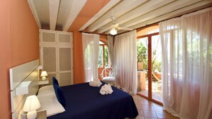 A bedroom with a bed, bedside lamps, a ceiling fan, and a view of the outdoors. - Porto Rotondo Center - free parking (Porto Rotondo)