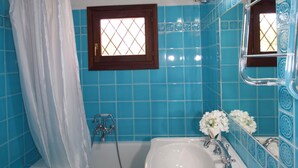 A bathroom with a bathtub, a sink, and a toilet. - Porto Rotondo Center - free parking (Porto Rotondo)