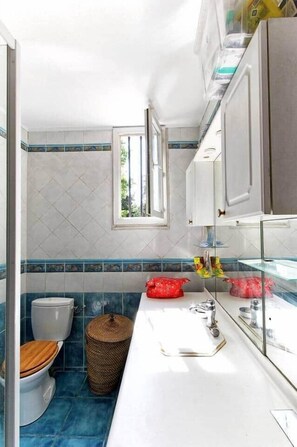 Een badkamer met toilet, wastafel en raam.
