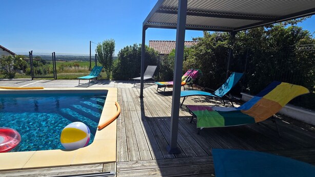 Una piscina con lettini e solarium.