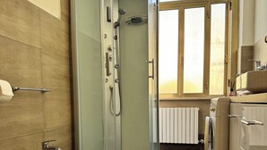A modern bathroom with a glass-enclosed shower, a toilet, and a sink. - Apartment 2 rooms - house Martina LuxRental Apartments (Pescara)