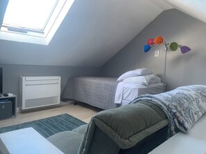 Une chambre de dortoir équipée d’un lit, d’un bureau, d’un radiateur et d’une fenêtre.