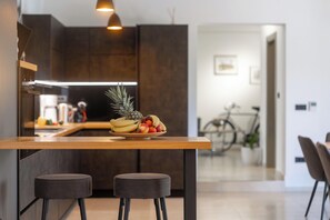A modern kitchen with a wooden island, two stools, and a fruit bowl. - Villa with pool for 6 people, children's playground, darts, table tennis table (Dračevac)