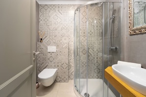 Une salle de bain avec douche, toilettes et lavabo.