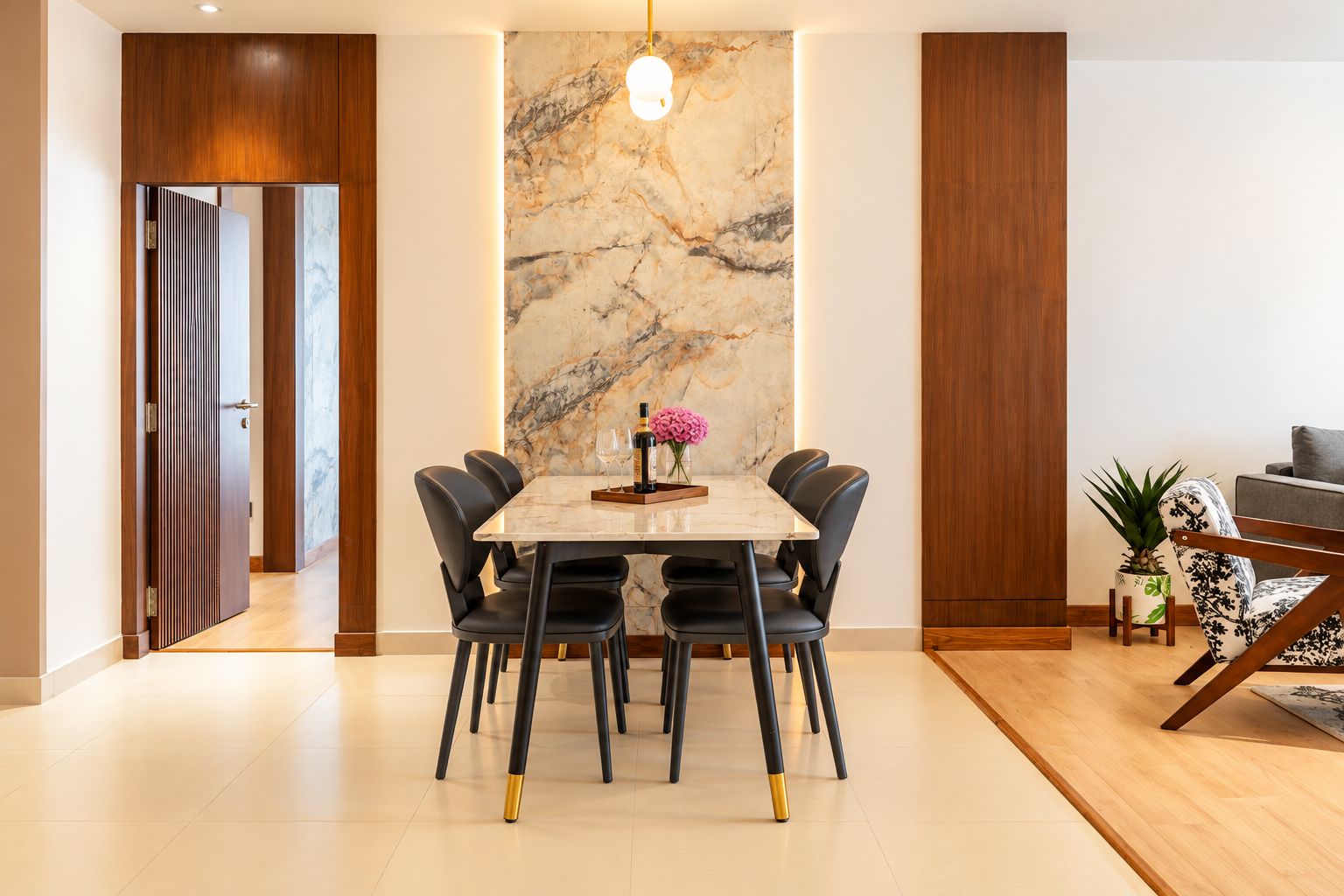 A modern dining area with a marble wall, a wooden door, and a seating arrangement.