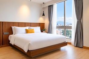 Moderni hotellihuone, jossa on suuri sänky, seinässä puupanelointi, näkymä kaupunkiin ja ikkuna, jossa on verhot.