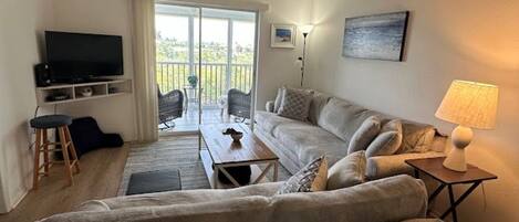 A living room with a sofa, TV, and a ceiling fan.