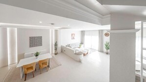 Amplia sala de estar con una mesa de comedor, sofás y una zona de cocina.