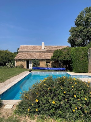 A swimming pool with a stone building in the background.
