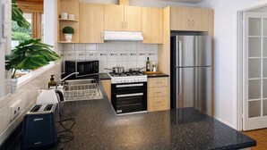Una cocina moderna con armarios de madera, un refrigerador de acero inoxidable, un microondas, una estufa y un tostador.
