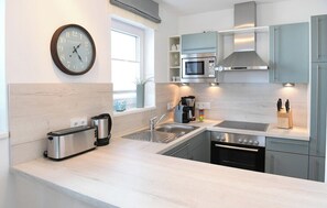 Eine moderne Küche mit integriertem Mikrowellenherd, Backofen und Edelstahlgeräten.