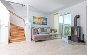 Ein modernes Wohnzimmer mit Sofa, Couchtisch und Kamin.