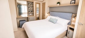 A bedroom with a bed, bedside tables, a wardrobe, and a mirror. - Tattershall Lakes Winchester Retreat With Hot tub (Lincoln)
