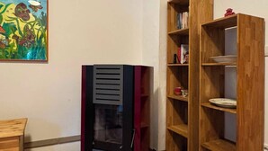 A room with a wooden floor, a bookshelf, a cabinet, and a painting on the wall. - Hidden in the forest - cozy vacation home for quiet days in nature (Wittingen)
