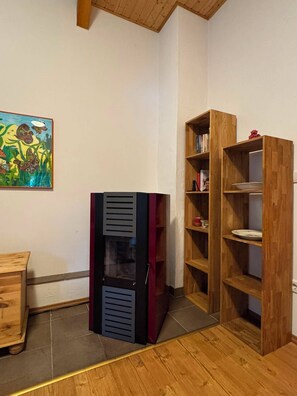 A room with a wooden floor, a bookshelf, a cabinet, and a painting on the wall. - Hidden in the forest - cozy vacation home for quiet days in nature (Wittingen)