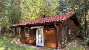A small wooden cabin with a red-tiled roof, a white door, and windows. - Hidden in the forest - cozy vacation home for quiet days in nature (Wittingen)