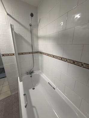 A bathroom with white tiles, a shower, and a bathtub. - The Shed - Cosy 2-Bed Flat with Free Parking - Close to City Centre (Cardiff)