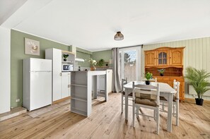 Eine kleine Küche mit Kühlschrank, Mikrowelle und Holzschränken.