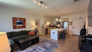 Un appartement moderne comprenant un salon, une cuisine et un coin repas.
