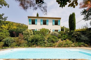 Ein zweistöckiges Haus mit Schwimmbecken davor.