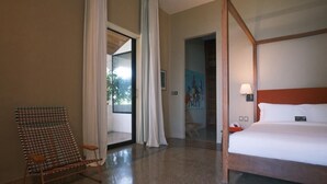A hotel room with a four-poster bed, a chair, a door leading to a balcony, and a painting on the wall. - Le Séku bi (Dakar)