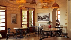 A restaurant with round tables, chairs, and hanging woven light fixtures. - Le Séku bi (Dakar)