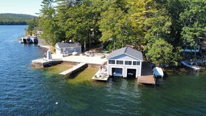 Un chalet au bord du lac, doté d’un quai, d’un petit abri pour bateaux et d’une terrasse couverte.