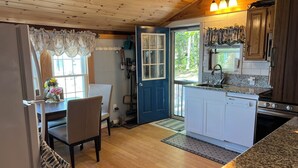 A kitchen with wooden cabinets, a built-in dishwasher, and a granite countertop. - STAY ABOVE THE WATER ON BEAUTIFUL LAKE WINNIPESAUKEE (Laconia)