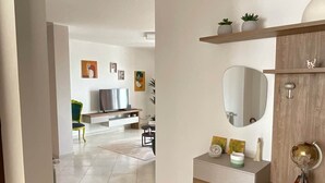 Una sala de estar moderna con un sofá, televisor y elementos decorativos.