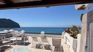 A covered outdoor area with a pool, lounge chairs, and a view of the sea. - SEA VIEW apartment OCEAN Cava dell'isola • Elowen (Forio)