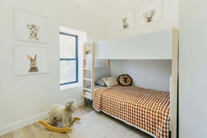 A child's bedroom with a bunk bed, a rocking horse, and framed animal pictures on the wall. - Historic Luxury 2-bedroom apartment in Cross Plains, WI (Cross Plains)