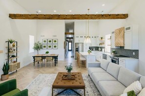 A modern living room with a sofa, coffee table, and dining area. - Historic Luxury 2-bedroom apartment in Cross Plains, WI (Cross Plains)