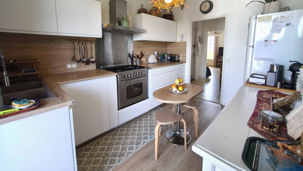 A modern kitchen with a stove, oven, and various appliances. There is a dining area with a table and chairs. - Bright apartment with balcony in Ajaccio (Ajaccio)