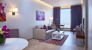 Una sala moderna con sofá, mesa de centro y vista a la ciudad.