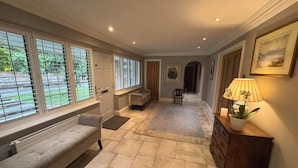 A hallway with a bench, a lamp, and a door leading to another room. - A charming English country home set in a beautiful village 28 miles from London! (Penn)