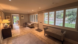 A spacious living room with a large window, a fireplace, and a cozy seating area. - A charming English country home set in a beautiful village 28 miles from London! (Penn)