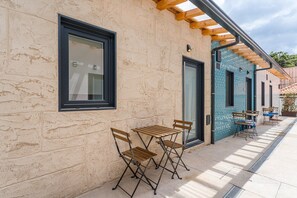 A building with a stone facade, a wooden pergola, and outdoor seating. - GuestReady - Miriam's Place (Campanhã)