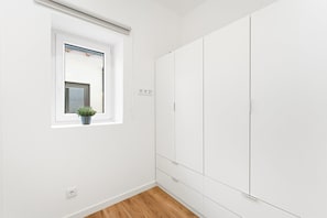 A room with a window, a potted plant, a wardrobe, and a wooden floor. - GuestReady - Miriam's Place (Campanhã)