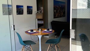 A modern room with a glass partition, a round table with chairs, and cityscape artwork on the walls. - LK Santo Antônio 1 (Belo Horizonte)