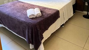 A bedroom with a bed, a headboard, a window, and two wall-mounted pictures. - LK Santo Antônio 1 (Belo Horizonte)