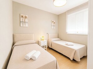 A hotel room with two beds, a nightstand with a lamp, and artwork on the walls. - Essence Chiclana 1 . (Chiclana de la Frontera)