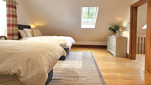 Un dormitorio con una cama grande, un aparador, una ventana y un tragaluz.