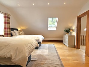 Ein Schlafzimmer mit einem großen Bett, einem Schminktisch, einem Fenster und einem Oberlicht.