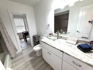 Une salle de bain avec des toilettes, un lavabo et un miroir.