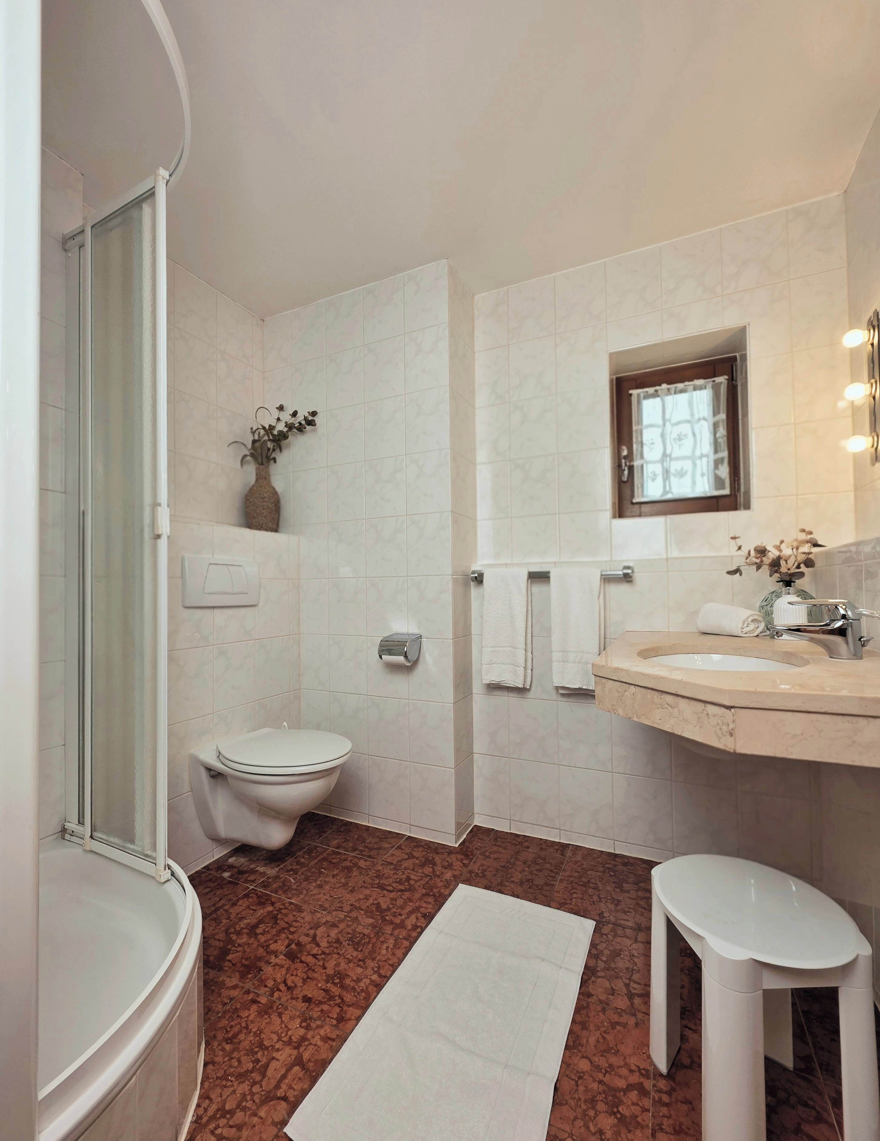 Une salle de bain comprenant des toilettes, un lavabo et un espace douche.