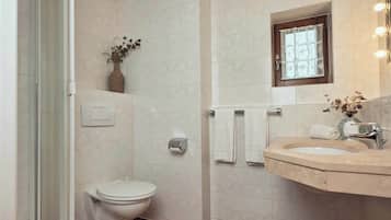 Une salle de bain comprenant des toilettes, un lavabo et un espace douche.